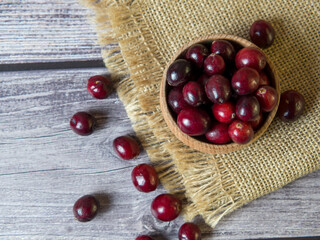 large cranberries in a wooden bowl on a wooden background. Healthy food and nutrition. Place for text.
