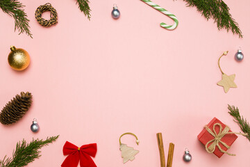 Christmas background with gift box and decorations on light pink. Preparation for holidays. Top view with copy space. Christmas composition. Flat lay.