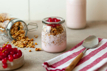 Obraz na płótnie Canvas greek yogurt parfait dessert with red currant and granola in mason jar