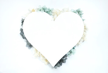 Flowers composition from blue and yellow flowers in the form of a heart on white background. Spring, summer template for your projects