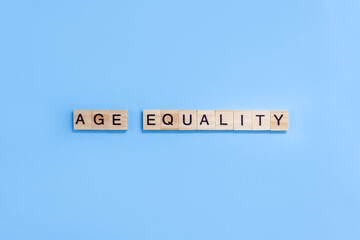 Words Age Equality. Wooden blocks with letters on blue background. Age discrimination concept. Copy space. - obrazy, fototapety, plakaty
