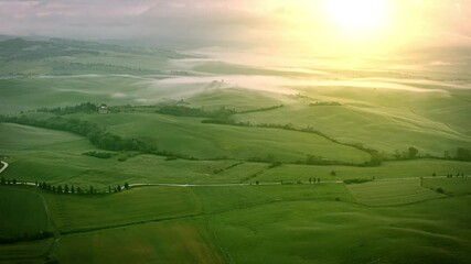 Flying over the foggy Tuscany Italy landscape at dawn