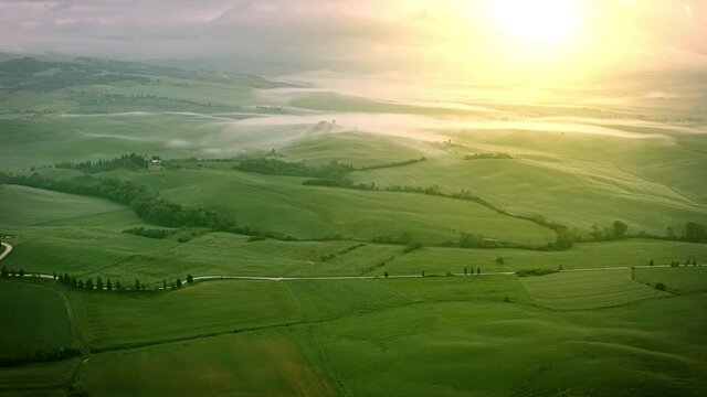 Flying over the foggy Tuscany Italy landscape at dawn