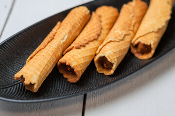 Wafer rolls with condensed milk. Thin and Crispy Waffle. Selective focus