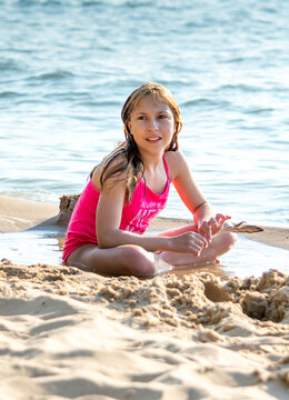 Young tween girl decorating a sand castle on lake Michigan 