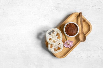 Body scrub and other care products on a wooden plate, isolated.