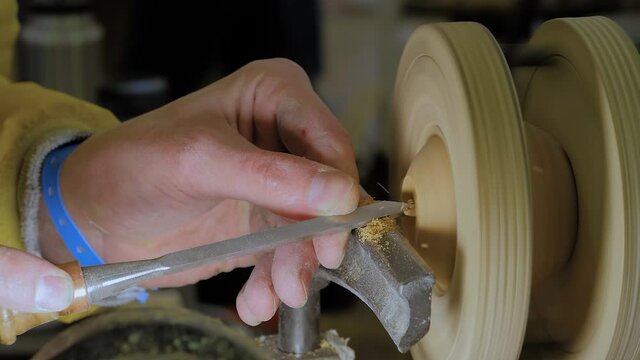 Man Carpenter Using Chisel For Shaping Piece Of Wood On Turning Lathe Machine With Many Shavings, Making Decorative Wooden Ball - Close Up, Slow Motion. Carpentry, Woodworking And Hobby Concept