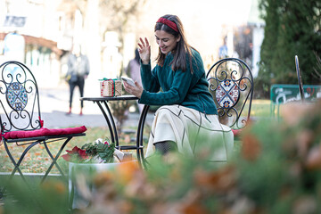 Attractive young woman uses smartphone, Christmas online shopping.