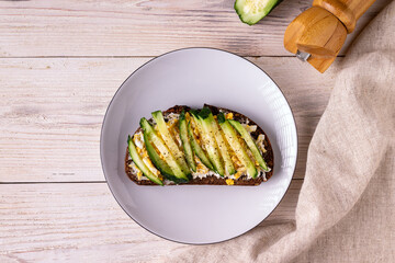 sandwich with cheese, egg, cucumbers, spices on a white wooden background copy space