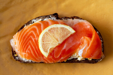 sandwiches with cheese, salted trout on a clay yellow plate close-up