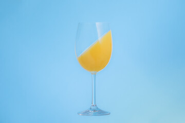 glass of orange juice blue background