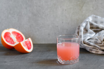 Glass of grapefruit juice on black surface