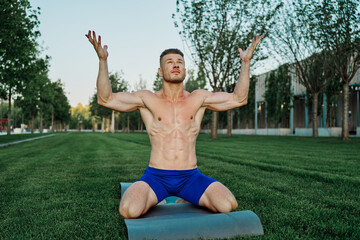 Obraz premium sports muscular man doing fitness crossfit in the park