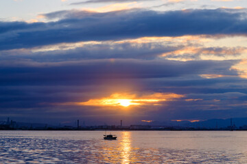 兵庫県芦屋市芦屋浜の夜明け。日の出とともに
あたりはオレンジ色に染まる。大阪湾を隔てて大阪市街地のビルがシルエットで浮かぶ
