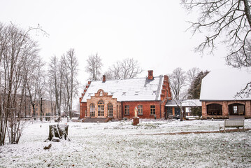 Red brick manor in snowy winter day, Kurmene, Latvia
