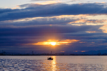 兵庫県芦屋市芦屋浜の夜明け。日の出とともに
あたりはオレンジ色に染まる。大阪湾を隔てて大阪市街地のビルがシルエットで浮かぶ