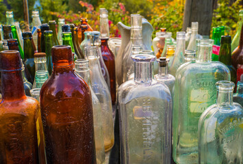 assorted old glass bottles displayed for sale 

