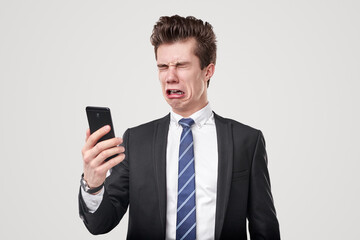 Sad funny businessman crying and using smartphone