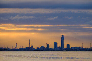 兵庫県芦屋市芦屋浜の夜明け。日の出とともに
あたりはオレンジ色に染まる。大阪湾を隔てて大阪市街地のビルがシルエットで浮かぶ