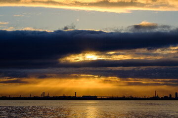 兵庫県芦屋市芦屋浜の夜明け。日の出とともに
あたりはオレンジ色に染まる。大阪湾を隔てて大阪市街地のビルがシルエットで浮かぶ
