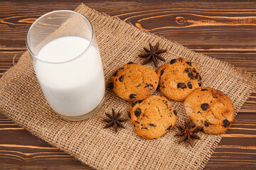 Obraz na płótnie Canvas Tasty chocolate chips cookies with milk on wooden table