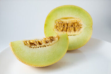 Ripe Gaul melon, cut in half with the seeds showing. Tropical fruit with white streaks on the...