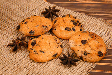 Tasty chocolate chips cookies with anise on wooden table