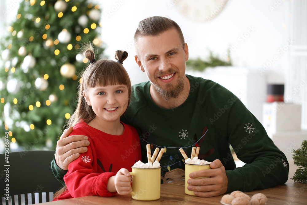 Wall mural happy daughter and father with cups of hot cocoa at home