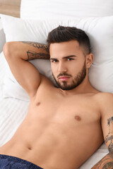Sexy young man in underwear lying on bed
