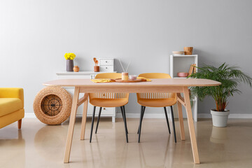 Dining table with reed diffuser and candle in interior of light room