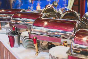 Beautifully decorated catering banquet table with different main course hot food dishes and garnish, with rice, chicken, lamb, vegetables and kebab on corporate party event or wedding celebration