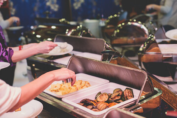 Beautifully decorated catering banquet table with different main course hot food dishes and garnish, with rice, chicken, lamb, vegetables and kebab on corporate party event or wedding celebration