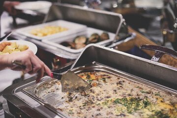 Beautifully decorated catering banquet table with different main course hot food dishes and garnish, with rice, chicken, lamb, vegetables and kebab on corporate party event or wedding celebration