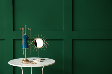 Table with mirror and jewellery near color wall