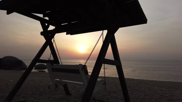 A lonely rocking chair on the beach where the morning sun rises