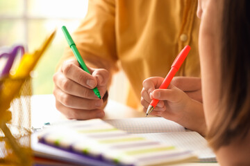 Man helping his little daughter to do lessons at home, closeup