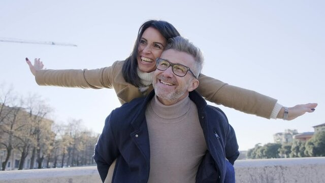 Adult couple in love having fun on city street - Husband and wife enjoying weekend outside activities on vacation - Happy lifestyle and holidays concept