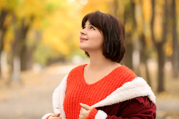 Smiling young woman in autumn park