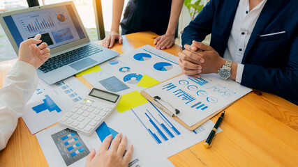 Close-up of young people having a business meeting in the office Businessmen chatting during a meeting with graphs and laptops with calculators to analyze financial computational data.