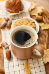 Cup of coffee with acorns and autumn leaves on table