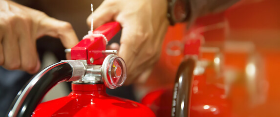 Fire extinguisher, Hand of engineer pull safety pin to using fire extinguisher tank of protection...