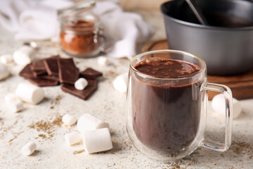 Glass cup of tasty hot chocolate on light background