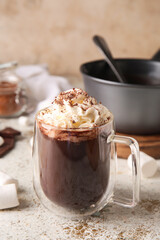Glass cup of tasty hot chocolate on light background
