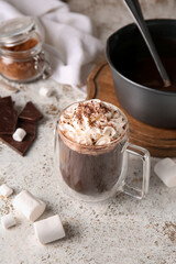 Glass cup of tasty hot chocolate on light background