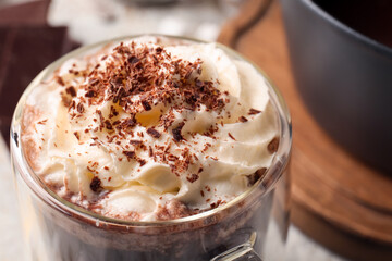 Glass cup of tasty hot chocolate on table, closeup