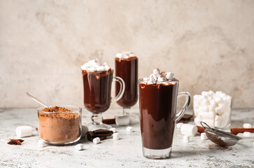 Glass cups of tasty hot chocolate with marshmallows on light background
