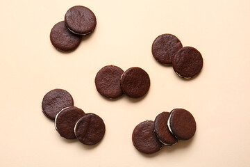 Tasty chocolate cookies with cream on beige background