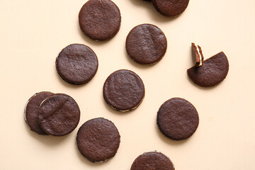 Tasty chocolate cookies with cream on beige background
