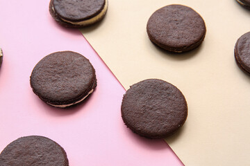Obraz na płótnie Canvas Tasty chocolate cookies with cream on color background, closeup