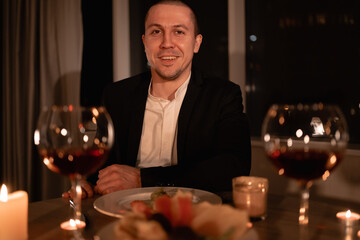 romantic dinner for valentine's day, man on february 14 at a table with wine, one lonely holiday love day, portrait of millennial man with glasses